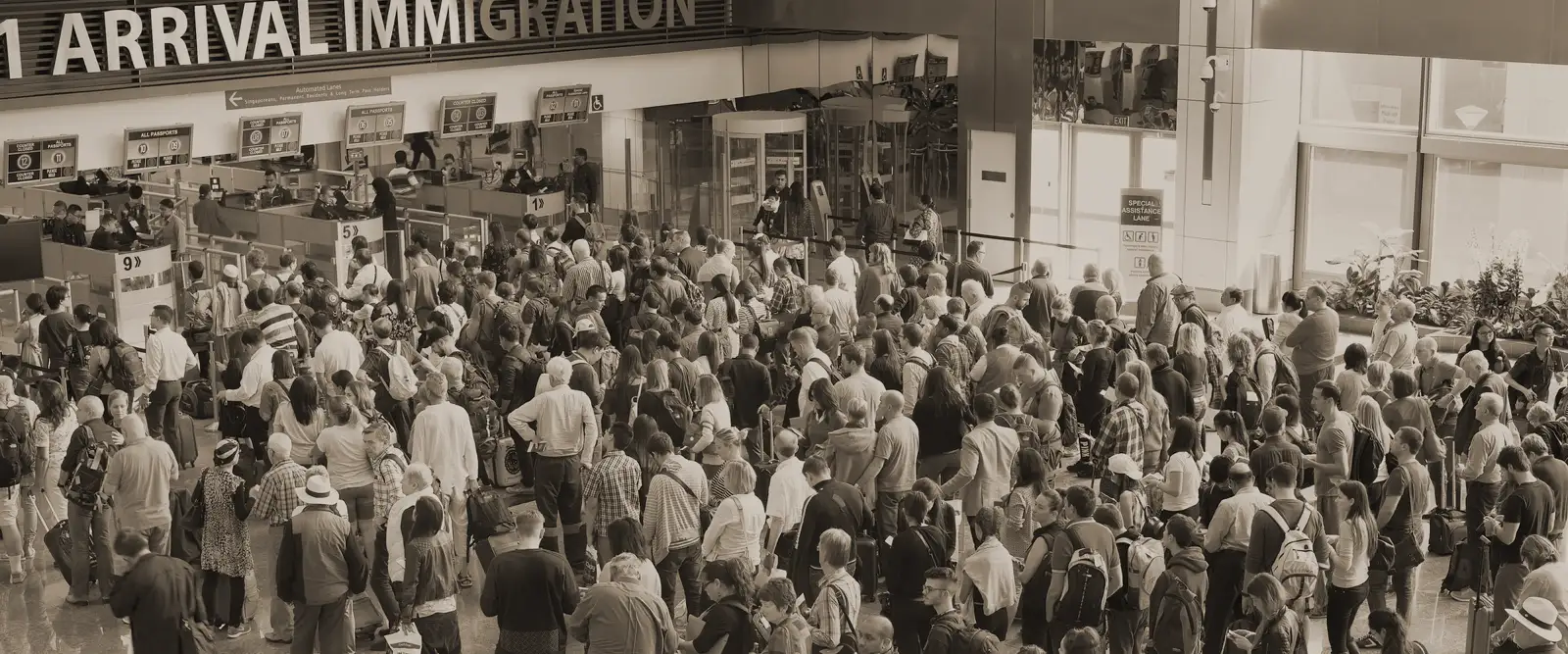 people waiting in line at an airport immigration check point