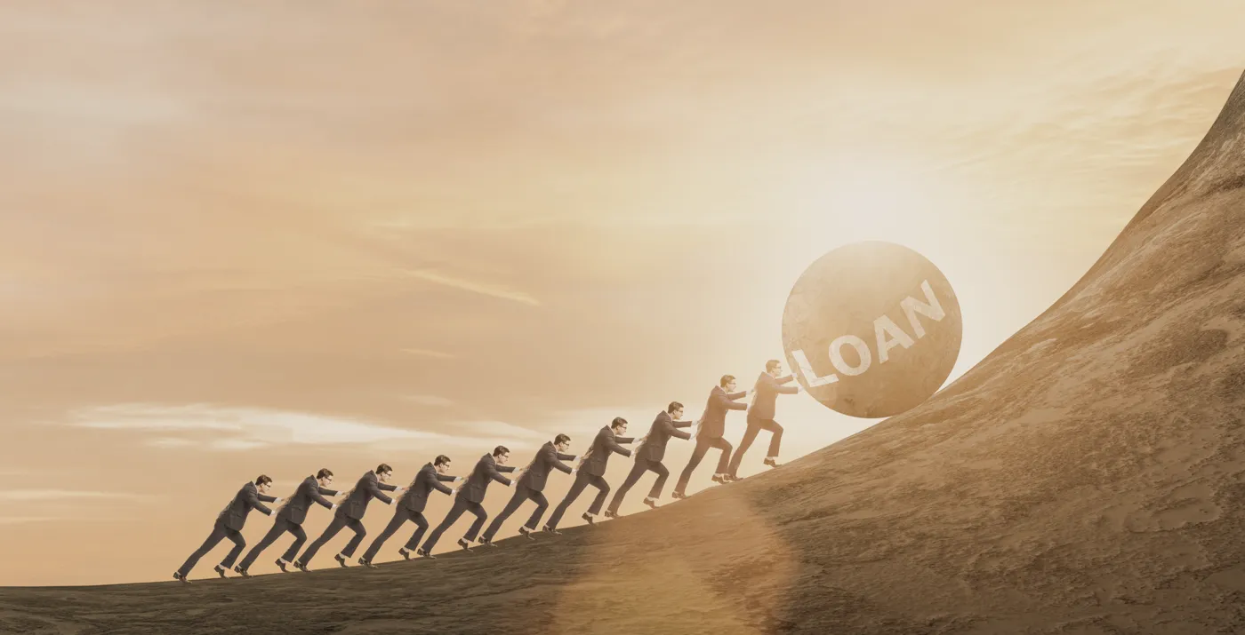 Group of people pushing a big ball of rock up the mountain slope.